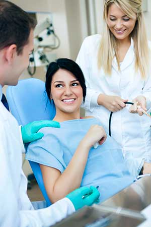 Smiling patient with dentist and hygenist