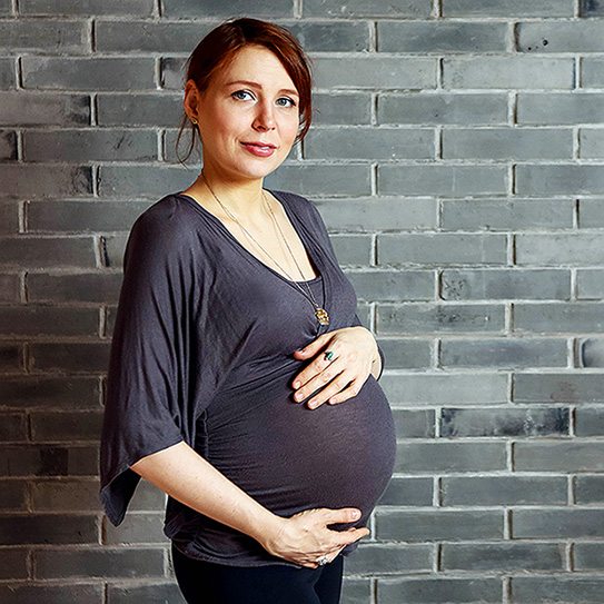 woman with hand on pregnant stomach