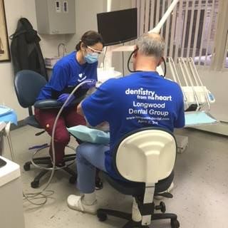 two dentists giving patient a cleaning