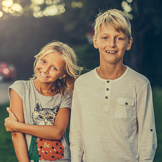 girl and boy smiling in yard