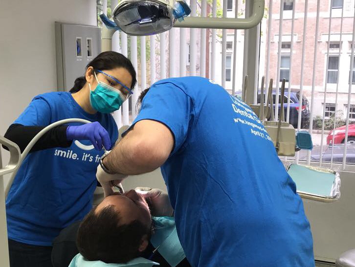 dentist working with patient at dental care event