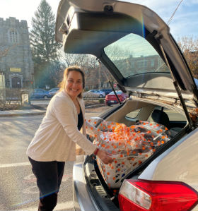 A woman loading goodies into the back of a car