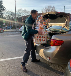 A man loading baskets into the trunk of a car