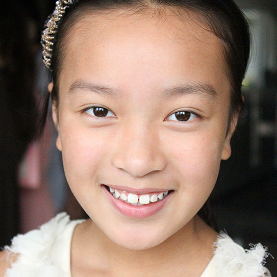 young girl smiling into camera
