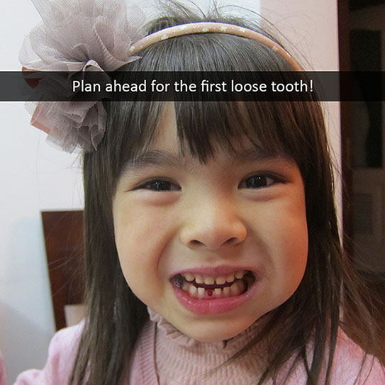 child showing her missing tooth