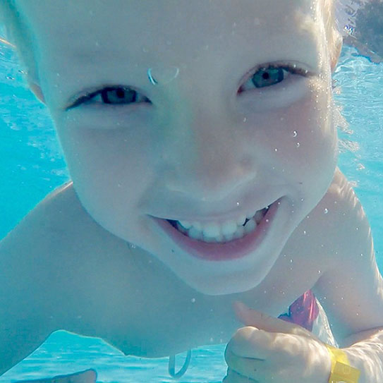 child smiling underwater