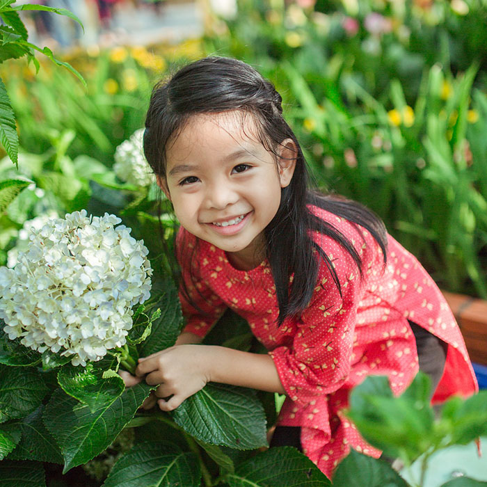 little girl smiling with a white flower