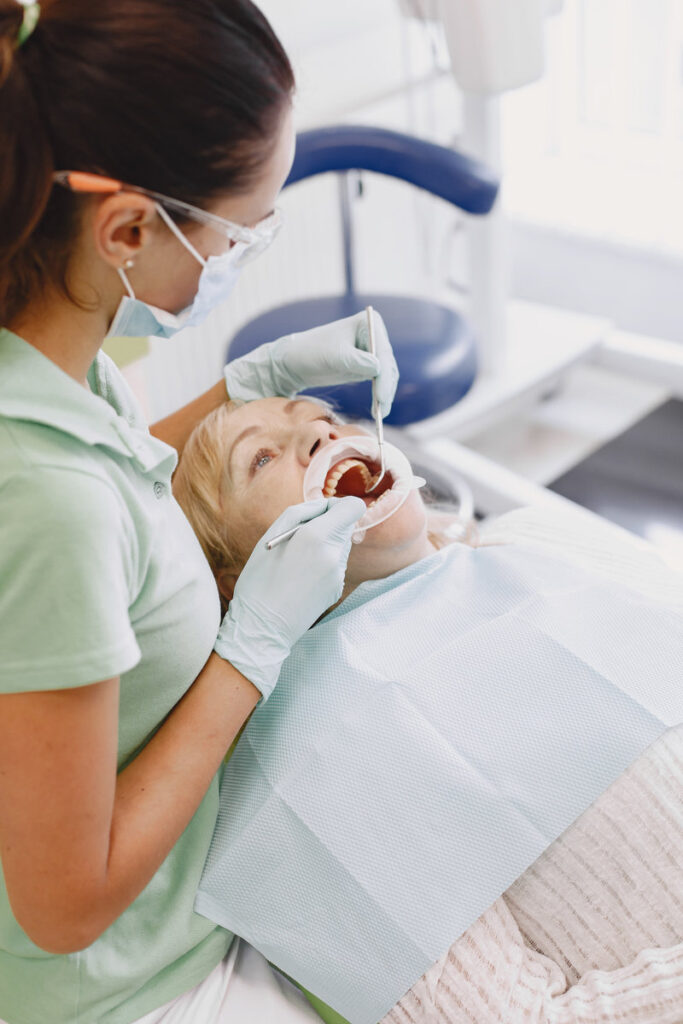 Senior woman having dental treatment at dentist's office. Woman is being treated for teeth