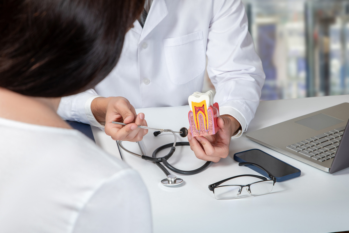 Doctor consulting a female patient about dental diseases .