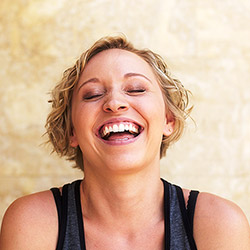 woman with eyes closed smiling