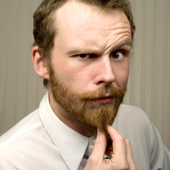 man pulling on beard while thinking