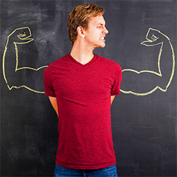 man in front of chalkboard with buff arms drawn